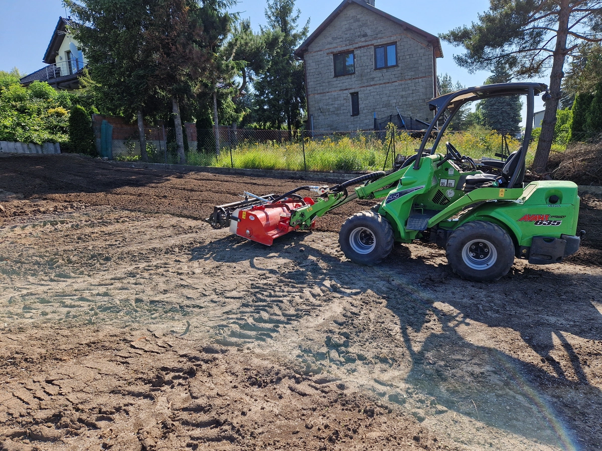 Miniładowarka z glebogryzarką rozluźniająca i niwelująca glebę na przygotowanym terenie. Praca glebogryzarką